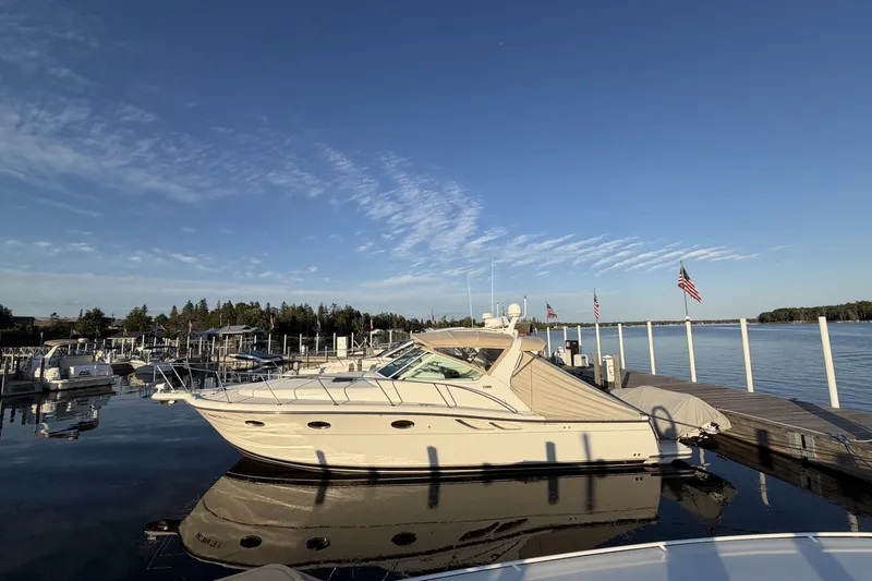 Slide: The Image of 1999 Tiara Yachts 3500 Open docked at a serene marina under clear skies. - 2