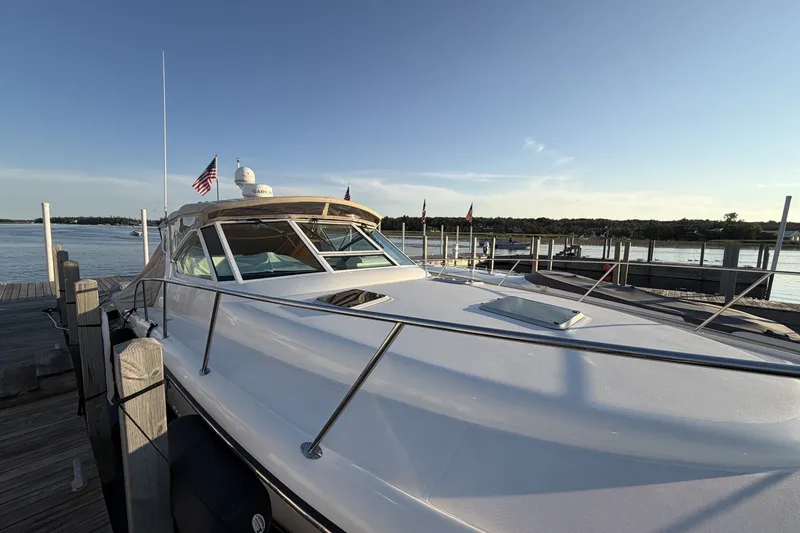Slide: The Image of 1999 Tiara Yachts 3500 Open docked, showcasing sleek design and American flag. - 11