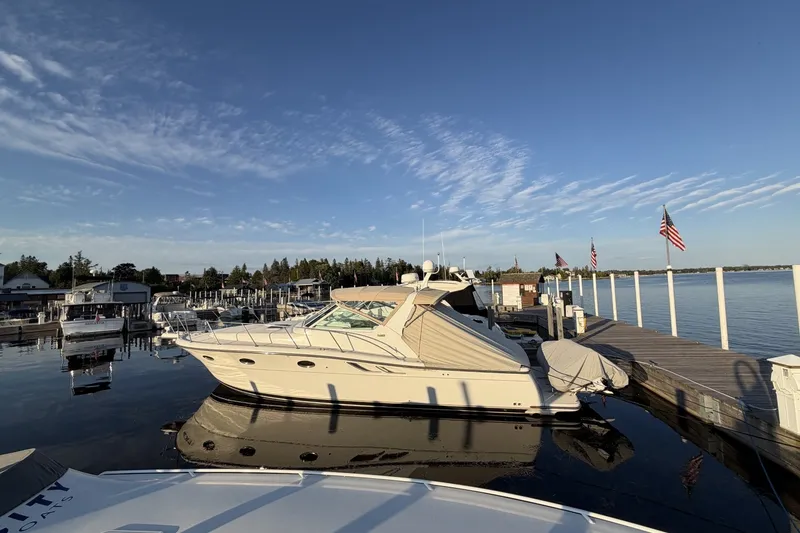 Slide: The Image of 1999 Tiara Yachts 3500 Open docked at marina under clear blue sky. - 3