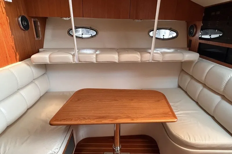 Slide: The Image of Interior of 1999 Tiara Yachts 3500 Open with cushioned seating and wooden table. - 31