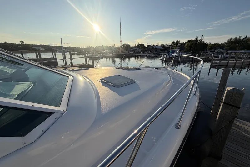 Slide: The Image of 1999 Tiara Yachts 3500 Open docked at sunset, reflecting sunlight on calm water. - 10
