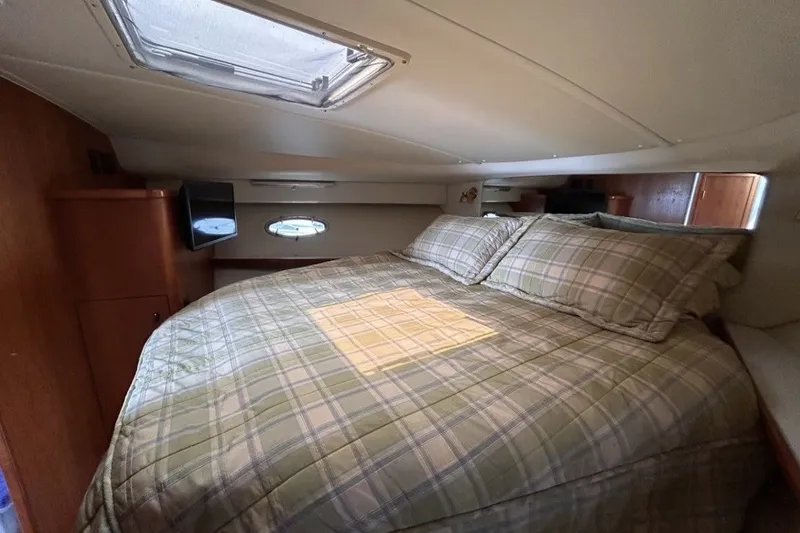 Slide: The Image of Cozy cabin interior of 1999 Tiara Yachts 3500 Open with plaid bedding and natural light. - 18