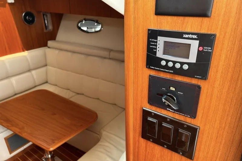 Slide: The Image of Interior of 1999 Tiara Yachts 3500 Open, featuring control panel and cozy seating area. - 41