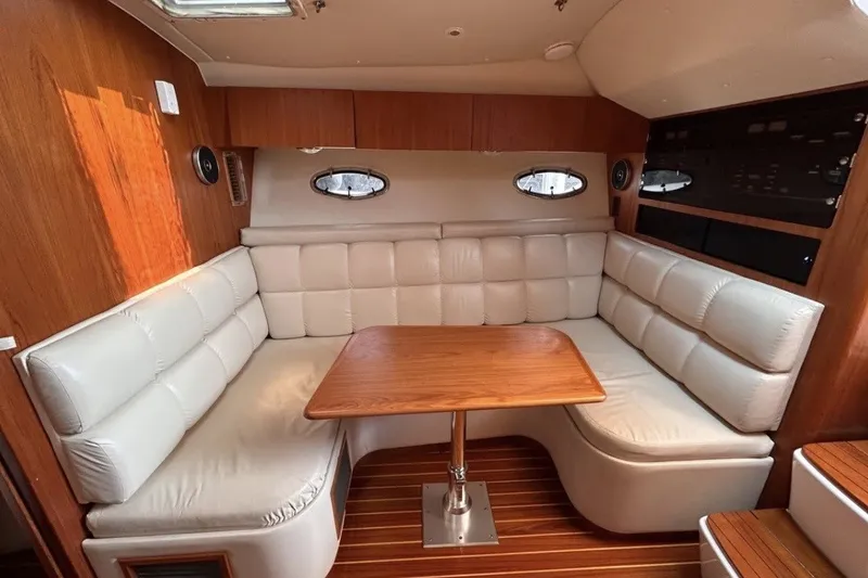Slide: The Image of Interior of 1999 Tiara Yachts 3500 Open with plush seating and wooden table. - 17