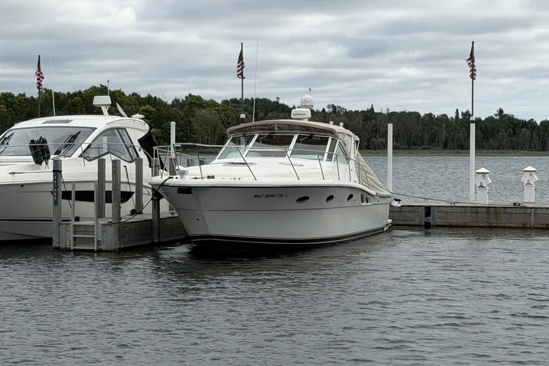 Slide: The Image of 1999 Tiara Yachts 3500 Open docked at marina with American flags. - 48