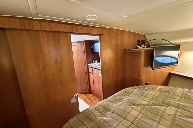 Slide: The Image of Interior of 1999 Tiara Yachts 3500 Open, featuring wood paneling and a cozy cabin space. - 45