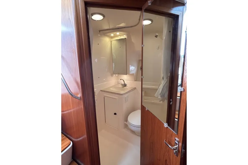 Slide: The Image of 1999 Tiara Yachts 3500 Open bathroom with sink, mirror, and wooden door. - 19