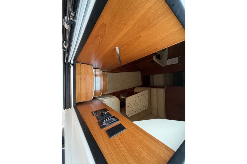 Slide: The Image of Interior view of 1999 Tiara Yachts 3500 Open, featuring wood paneling and seating area. - 26