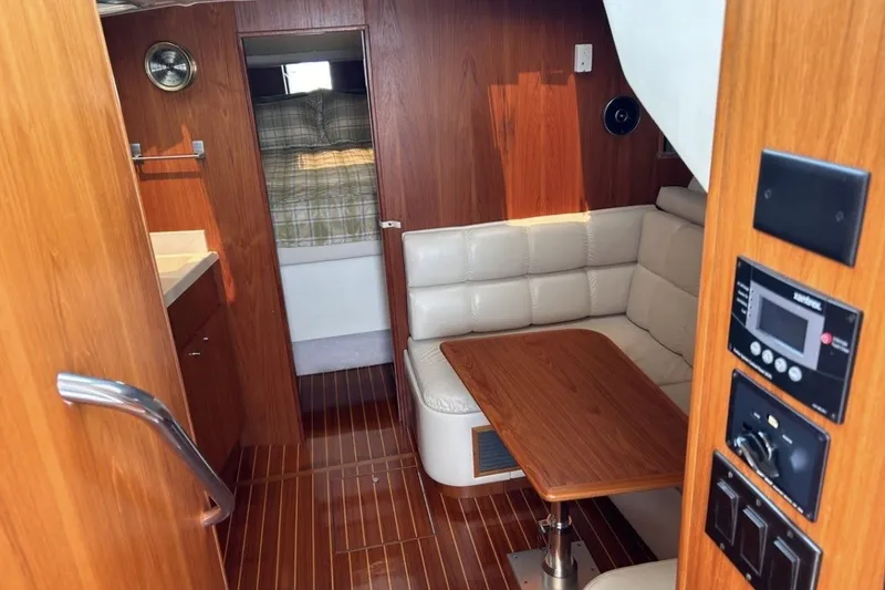 Slide: The Image of 1999 Tiara Yachts 3500 Open interior with wood finish, seating, and control panel. - 15