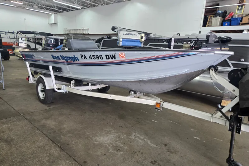 The Image of 1992 Sea Nymph FM161 boat on trailer in indoor showroom. - 1
