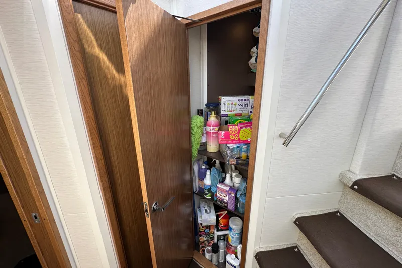 Slide: The Image of Storage cabinet on 2017 Sea Ray Sundancer 460 yacht, filled with various cleaning supplies. - 38