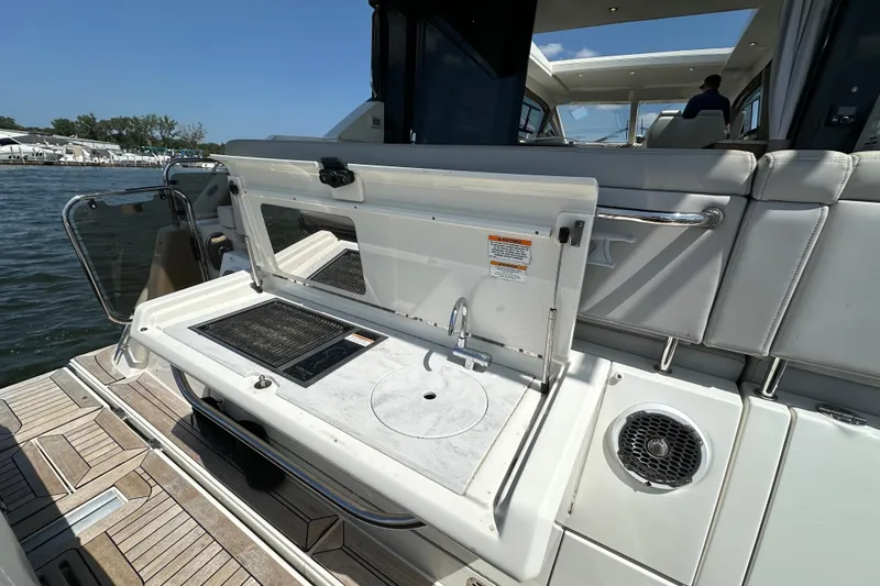 Slide: The Image of 2017 Sea Ray Sundancer 460 yacht with outdoor kitchenette and sink, docked by the water. - 5