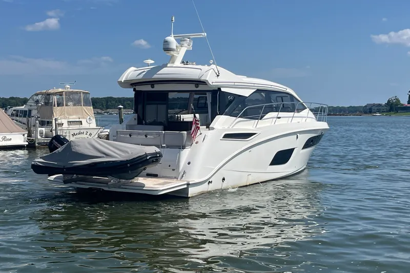 Slide: The Image of 2017 Sea Ray Sundancer 460 yacht docked on calm water under a clear blue sky. - 43