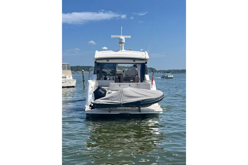 Slide: The Image of 2017 Sea Ray Sundancer 460 yacht with jet ski on water, clear sky background. - 4