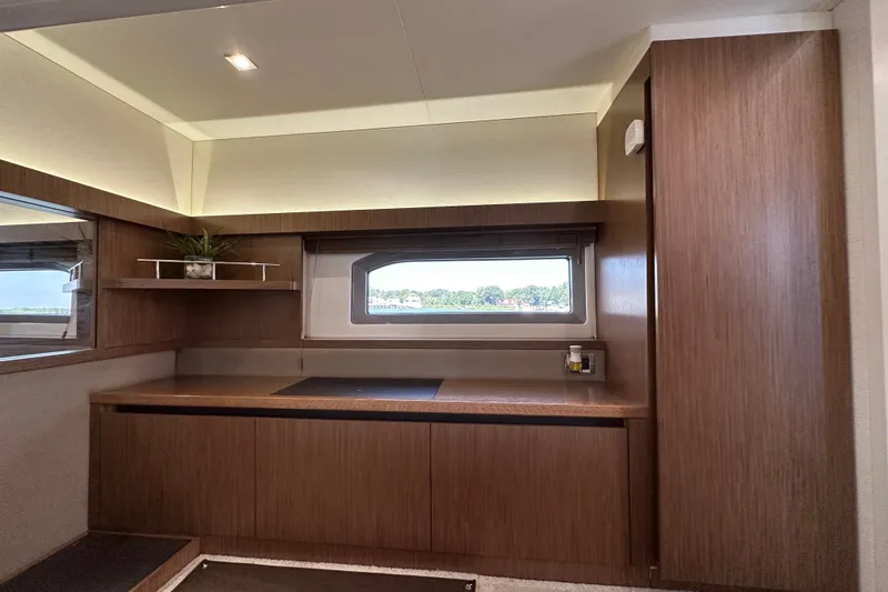 Slide: The Image of Interior of 2017 Sea Ray Sundancer 460 yacht with sleek wood cabinetry and window view. - 30