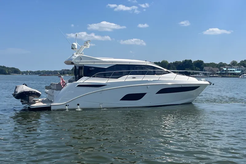Slide: The Image of 2017 Sea Ray Sundancer 460 yacht cruising on a calm lake under a clear blue sky. - 3