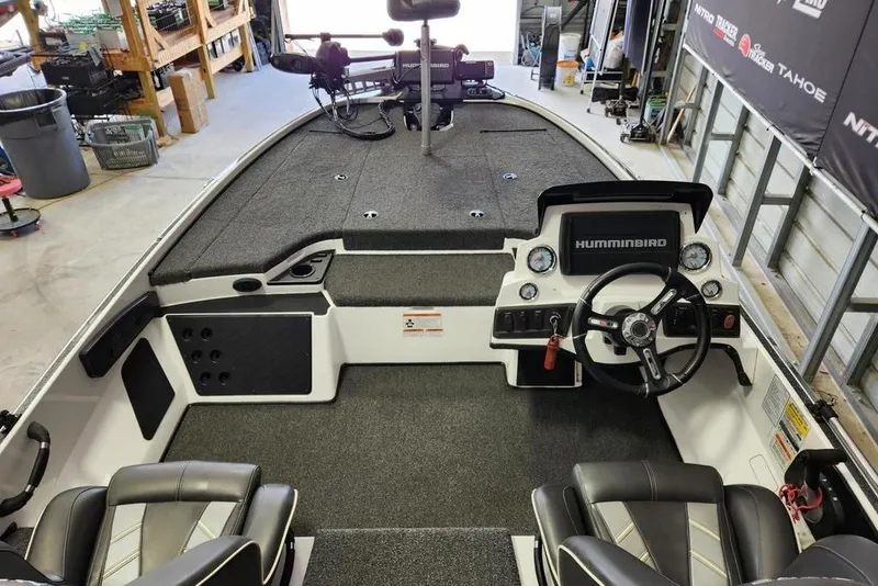 Slide: The Image of 2021 Nitro Z18 boat interior with steering wheel and Humminbird electronics in a garage setting. - 6