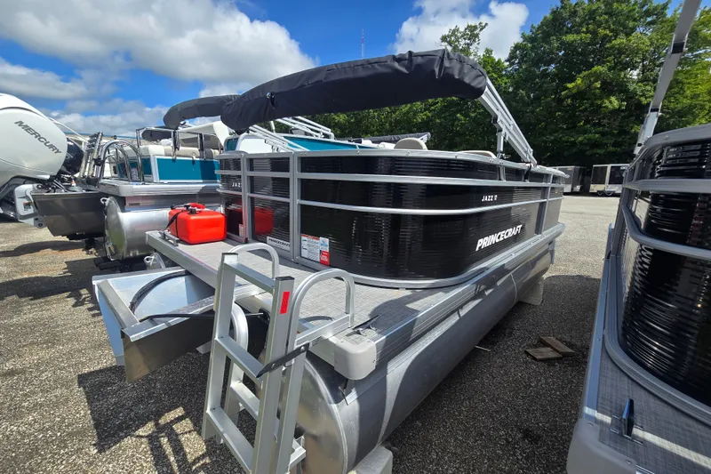 Slide: The Image of 2026 Princecraft Jazz 17 pontoon boat with canopy, docked outdoors under a blue sky. - 1