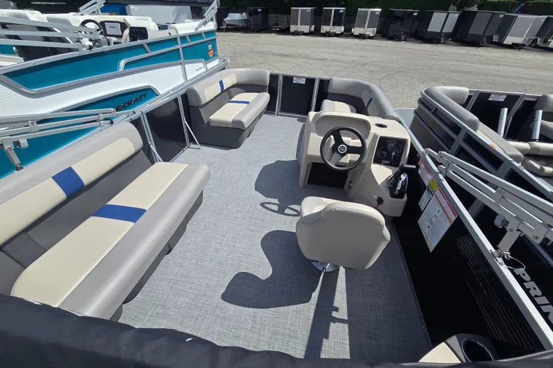Slide: The Image of 2026 Princecraft Jazz 17 pontoon boat interior with beige seating and steering console. - 3