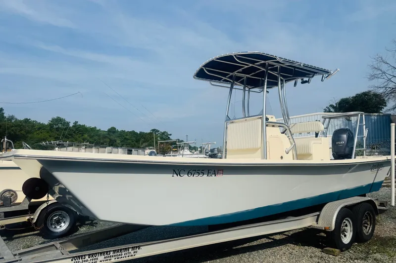 Slide: The Image of 2015 Jones Brothers Bateau 23 boat on trailer, featuring a T-top and outboard motor. - 2