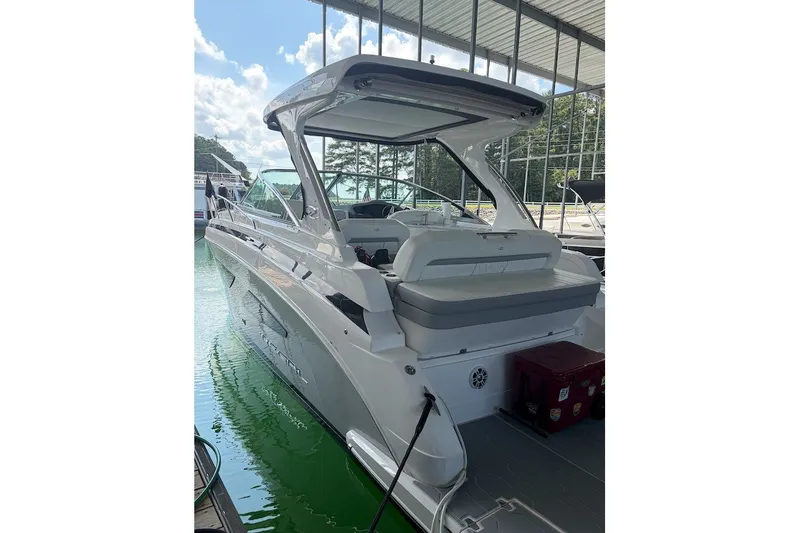 The Image of 2025 Regal 33 Express boat docked in a marina under a canopy. - 1