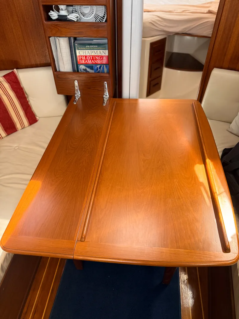 Slide: The Image of Interior of a 1992 Tartan T 31 featuring a wooden table and seating area. - 14
