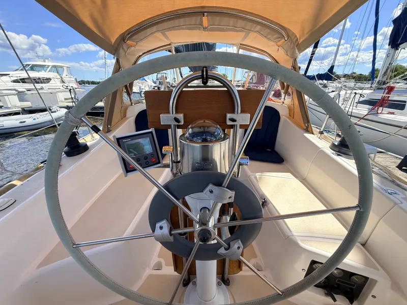 Slide: The Image of The cockpit of a 1992 Tartan T 31 with a large steering wheel and navigation instruments. - 6