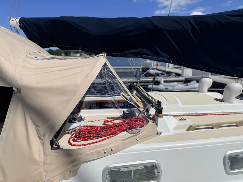 Slide: The Image of A 1992 Tartan T 31 sailboat with a beige cover and red ropes on the deck. - 4
