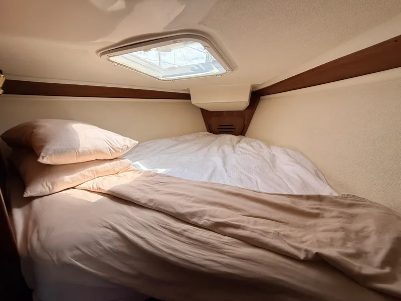 Slide: The Image of The cabin of a 1992 Tartan T 31 with a cozy bed and a skylight. - 19