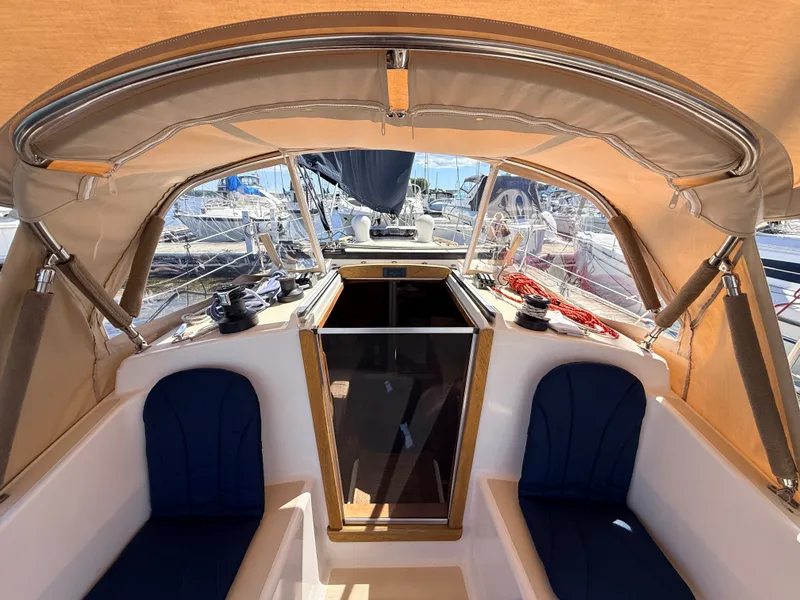 Slide: The Image of The cockpit of a 1992 Tartan T 31 with blue seats and a beige canopy. - 8