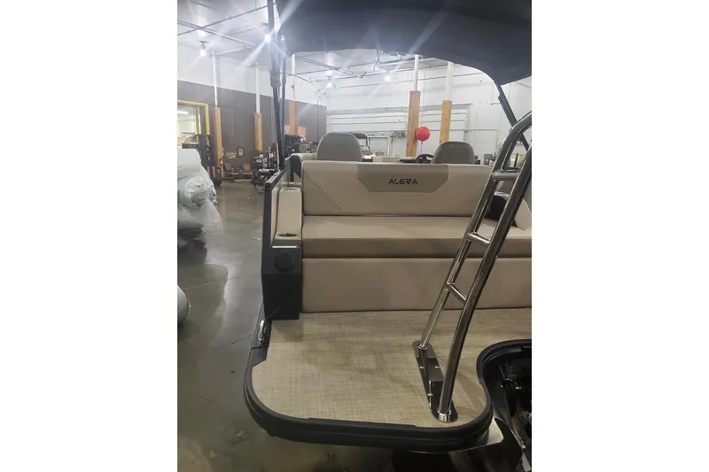 Slide: The Image of 2027 Alera A22L boat interior with seating and ladder in a showroom. - 14