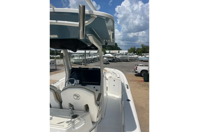 Slide: The Image of 2023 Edgewater 262CC boat with sleek design, parked outdoors under a cloudy sky. - 3