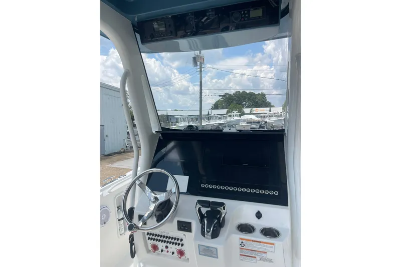 Slide: The Image of 2023 Edgewater 262CC boat dashboard with steering wheel and control panel. - 11