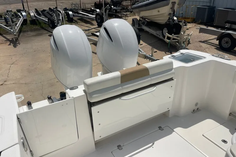 Slide: The Image of 2023 Edgewater 262CC boat with dual outboard motors and seating, in a marina setting. - 4