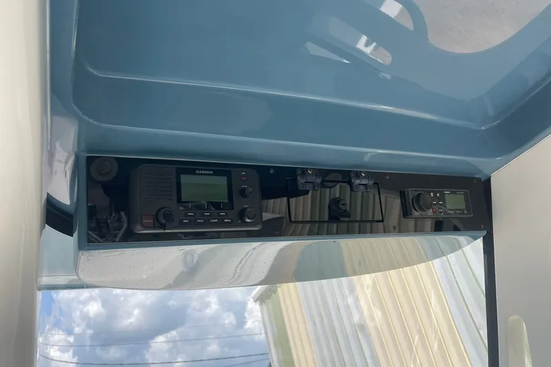 Slide: The Image of 2023 Edgewater 262CC boat console with Garmin electronics and clear sky reflection. - 8