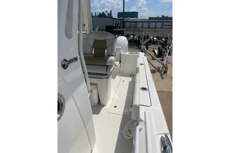 Slide: The Image of 2023 Edgewater 262CC boat interior with seating and storage, displayed outdoors. - 15