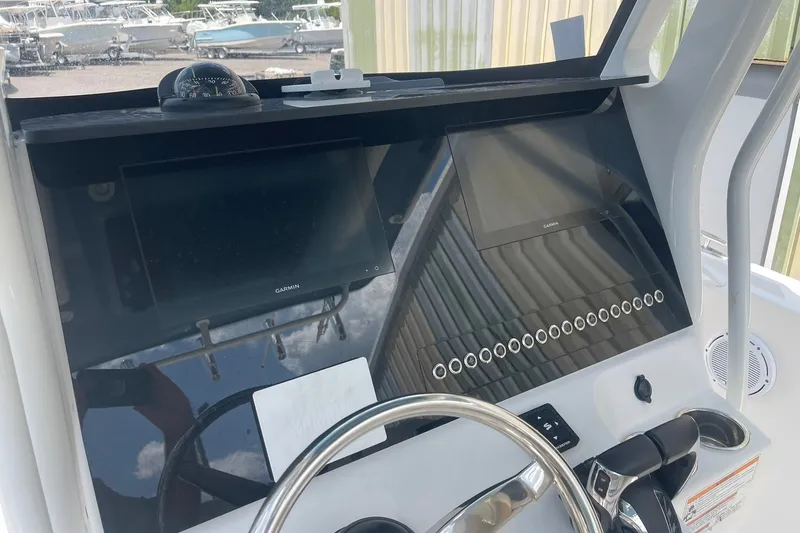 Slide: The Image of 2023 Edgewater 262CC boat dashboard with Garmin displays and steering wheel. - 7