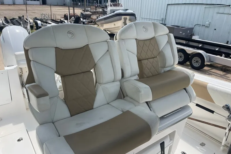 Slide: The Image of Luxury seating on 2023 Edgewater 262CC boat, featuring beige and white upholstery. - 12