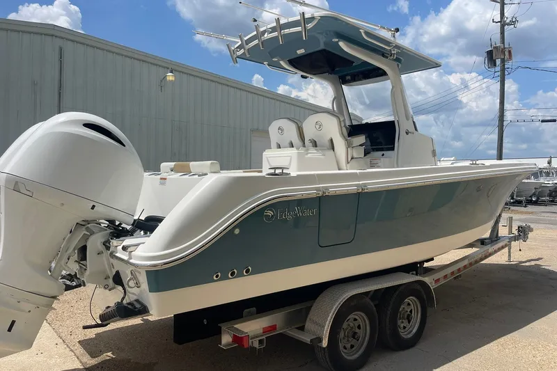 Slide: The Image of 2023 Edgewater 262CC boat on trailer, featuring sleek design and powerful outboard motor. - 2