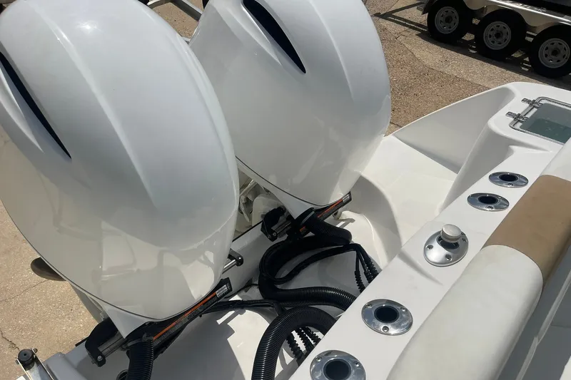 Slide: The Image of 2023 Edgewater 262CC boat with dual outboard engines and rod holders. - 17