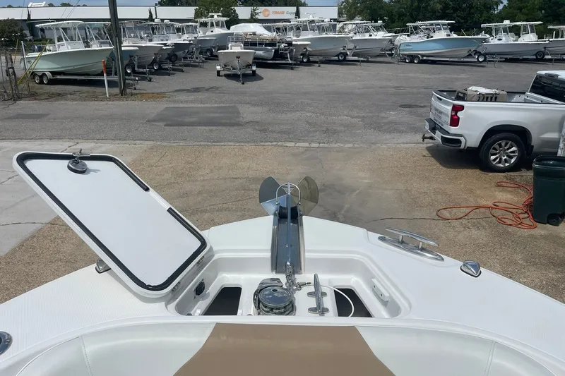 Slide: The Image of 2023 Edgewater 262CC boat at a dealership, surrounded by other boats and a truck. - 14