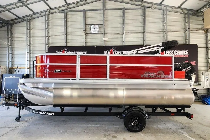 The Image of 2027 Sun Tracker Party Barge 16 DLX pontoon boat in a garage setting. - 1