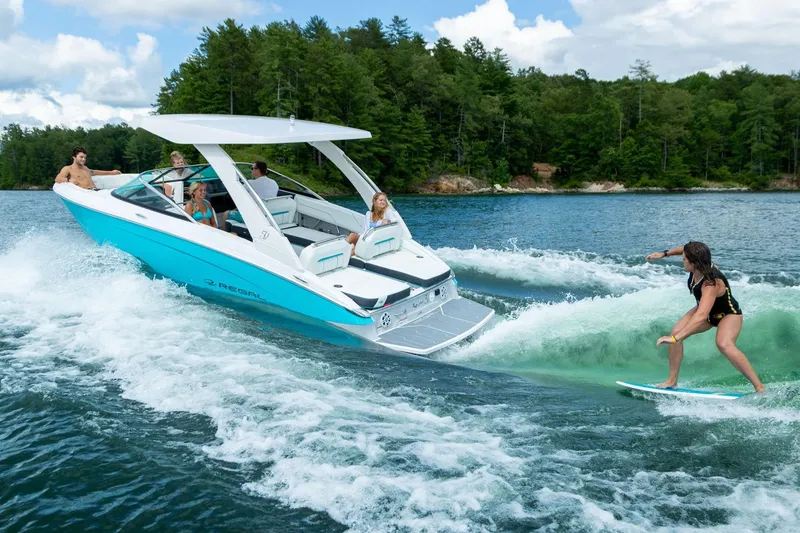 Slide: The Image of Manufacturer Provided Image: 2026 Regal LS4 Surf boat with people enjoying wake surfing on a lake. - 2