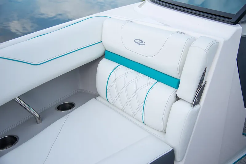 Slide: The Image of Manufacturer Provided Image: 2026 Regal LS4 Surf boat interior with white and teal seating, featuring cup holders. - 7