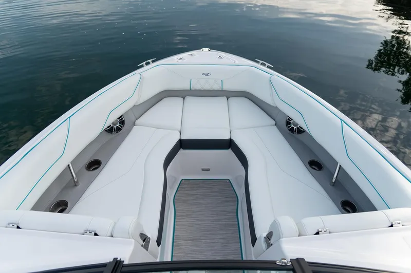 Slide: The Image of Manufacturer Provided Image: 2026 Regal LS4 Surf boat interior with white seating and cup holders on calm water. - 5
