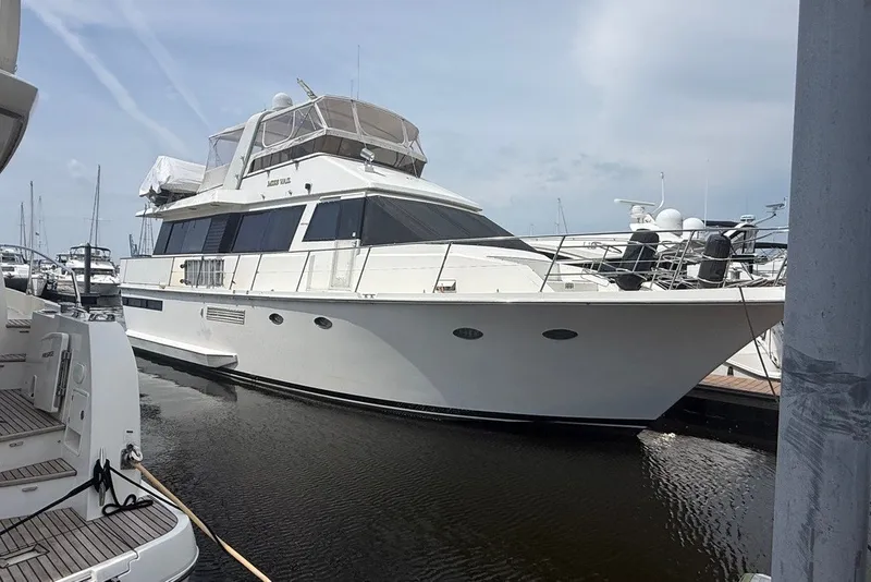 The Image of 1989 Viking 55 Motor Yacht docked at marina, showcasing sleek design and spacious deck. - 1