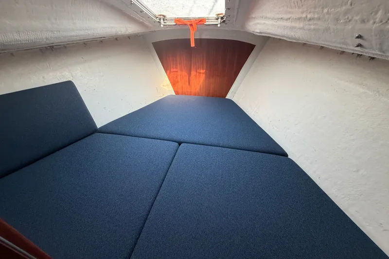 Slide: The Image of Interior cabin of 1984 C&C 33 MK II sailboat with blue cushions and wooden accents. - 52