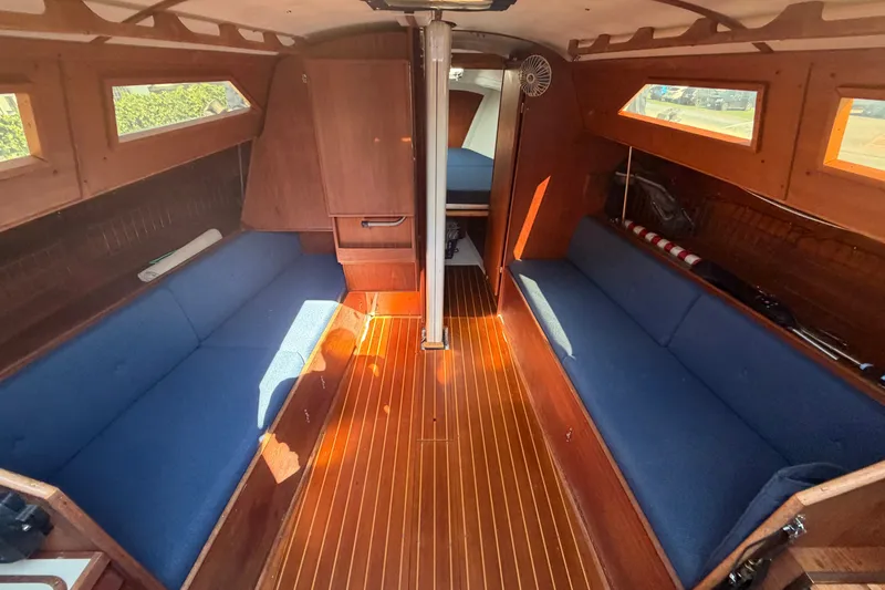 Slide: The Image of Interior of 1984 C&C 33 MK II sailboat with blue seating and wooden finishes. - 34