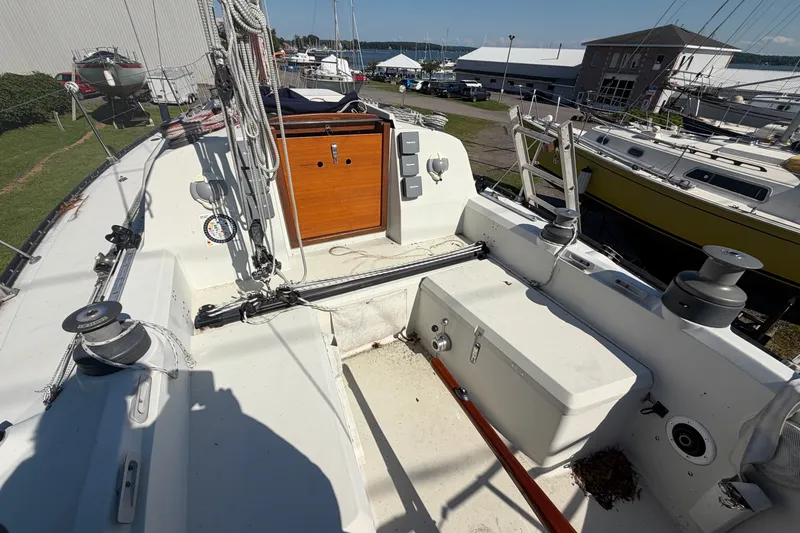 Slide: The Image of 1984 C&C 33 MK II sailboat cockpit with winches and ropes, docked at a marina. - 10