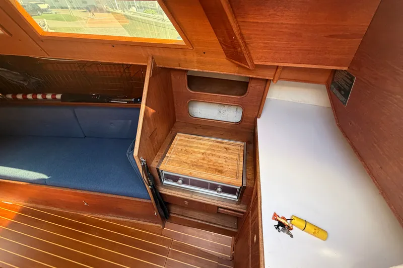 Slide: The Image of Interior of 1984 C&C 33 MK II sailboat with wooden cabinetry and blue seating. - 32